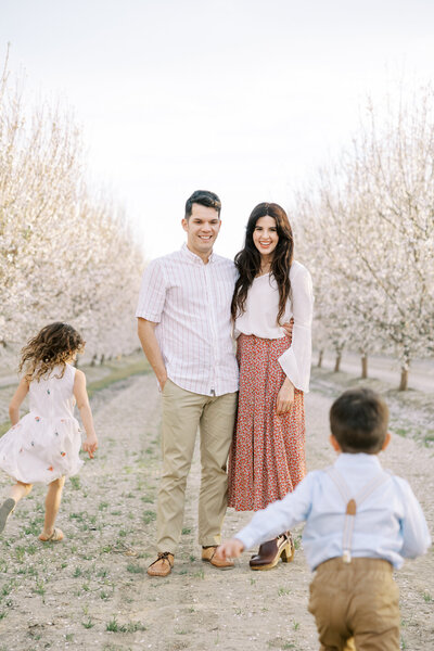Engaged couple poses together on a flower field in Fresno