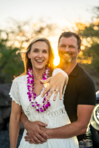 Couple showing off engagement ring during golden hour, taken by hawaii engagement photographer