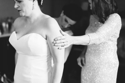 Black and white image of bride getting ready with Mom and Sister