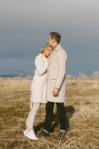 couple leaning on each other in a field