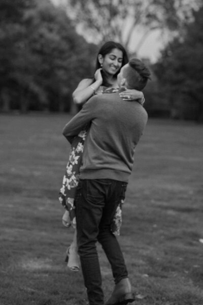 A person lifting up their partner as they both smile 