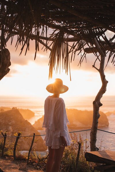 Woman looking out at a Bright glowing yellow sunset on a tropical Island