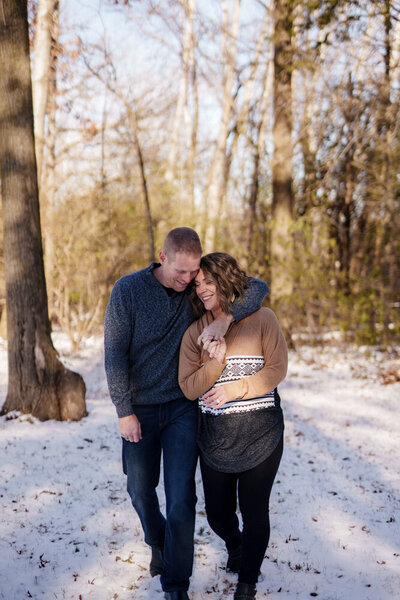 Jen and Mark Heller hugging with forest backdrop