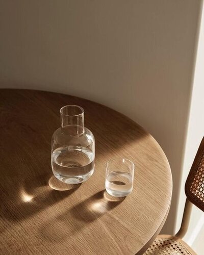 table avec un verre et un pichet d'eau