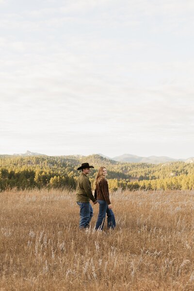 A couple walking in a field in Custer, South Dakota.
