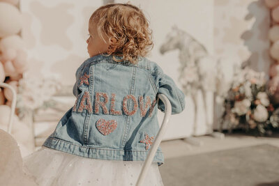 Little girl wearing personalized jean jacket for birthday party planned by Fancy Chancey in San Diego CA