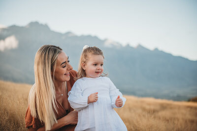 mum and daughter posing in fron of the Remakables in Queenstown during their family photography session in Queenstown