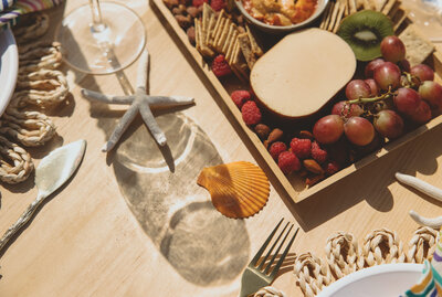 Let's Picnic Co. -outdoor table top decorated with seashells and snack tray