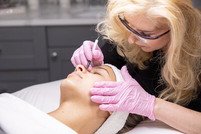 Kathleen giving a client a facial