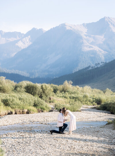 A man proposing to his girlfriend in the mountains in Aspen, Colorado by the PineCreek Cookhouse area shot by Kelly Elizabeth Photography.