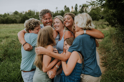 family in summer blues laughing in a giant group hug