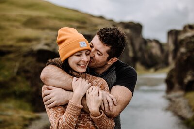 man kissing woman on cheek