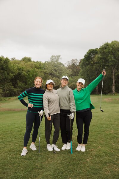 Maria stands with three friends at a golf tournament