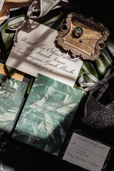 Tropical wedding invitation suite with green palm design and calligraphy envelope