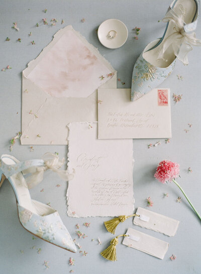 Neutral wedding invitations, vellum covered place cards with gold tassels and blue chinoiserie bridal heels