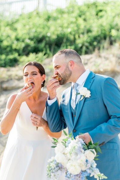 Bride and Groom eating lobster rolls on their wedding day at Pelham House on Cape Cod