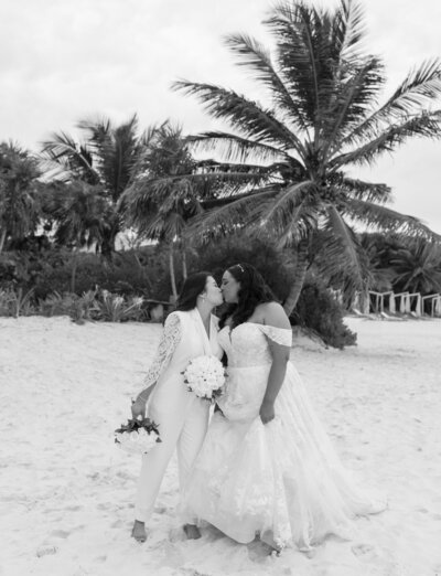 same-sex lesbian wedding in Mexico, two brides kiss on beach, destination wedding in Mexico