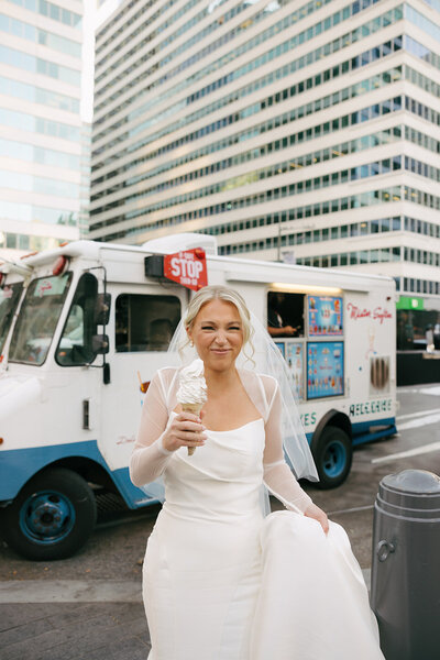 bride eating ice cream on her wedding day in the city 