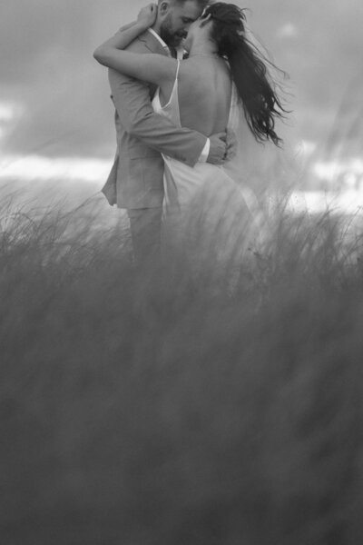 man and woman standing on a structure above the ocean