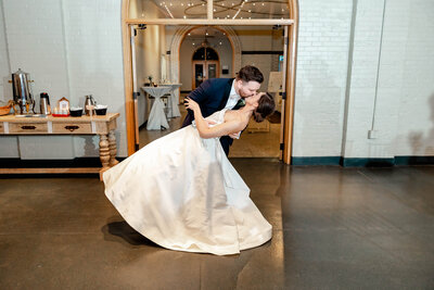 Romantic dip and kiss moment captured by Style & Grace Photography during the wedding reception send-off in St. Louis, MO, celebrating the couple’s love with a timeless gesture.