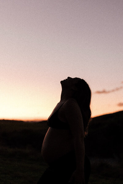 An empowering portrait of a pregnant woman basking in the Whakatane sunset. Captured by Eilish Burt Photography