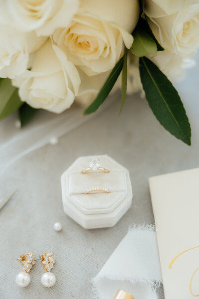 A cream white wedding flat lay on a pearl veil.