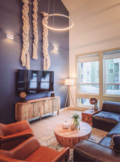 Cozy modern lounge at Cashin's Field in Nevada City  featuring leather seating, macramé wall art, and warm lighting.
