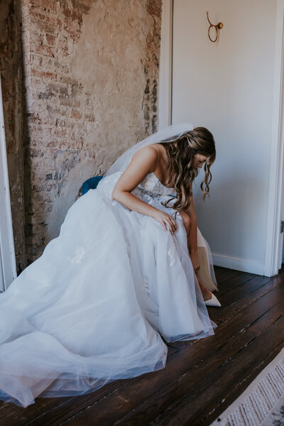 Minnesota Wedding Photographer captures bride putting on shoes