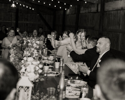 The maid of honor gives the catholic bride a hug after her toast at an ohio catholic wedding reception.