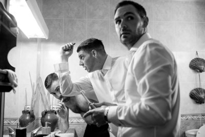 This is the best black and white getting ready photo of groom prep on a wedding day in Milagros in Spain. The groom, best man and usher all caught by surprise by Motiejus wedding photographer while second shooting for Adorlee
