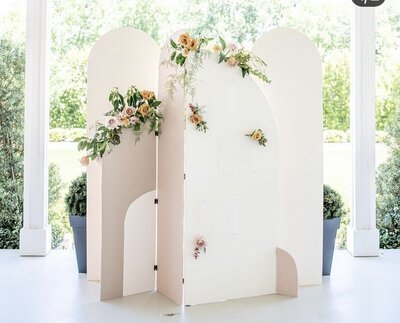White and pink custom arch backdrop design with florals and greenery