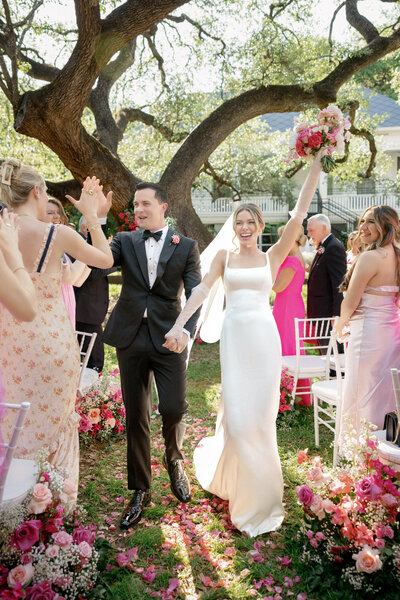 groom and blonde bride in white wedding dress and pink flowers