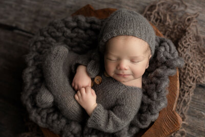 newborn-baby-boy-in-knit-romper-snuggled-in-bowl
