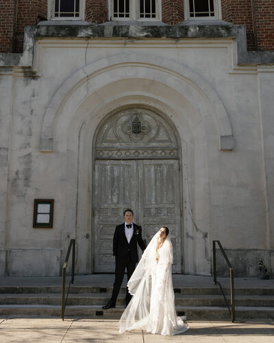 Newly weds in suit and wedding dress walk back down the aisle laughing. Backdrop is the vail mmountaions and a white floral covered cermony arch