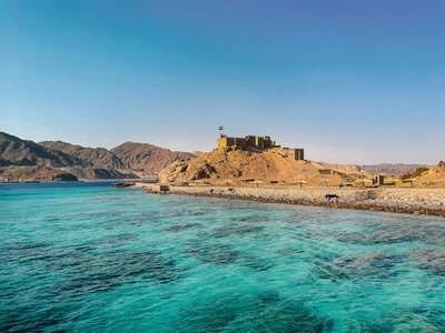 Crystal clear blue waters leading to rocky cliffs