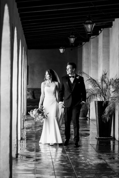 Bride and Groom walk down corridor looking out at their guests
