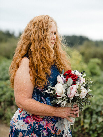 Maid of honor stands holding the bridal bouquet
