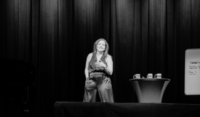 Erika Biddix speaking onstage at a women's leadership event.
