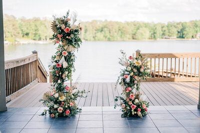 tall and short floral arbors sitting on the deck overlooking the water