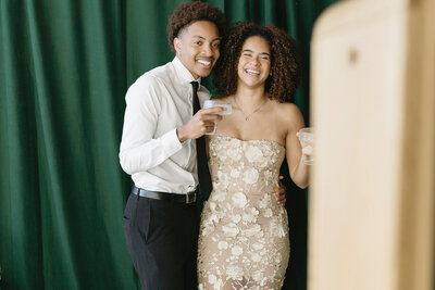 Engaged couple taking a photo with a print photo booth