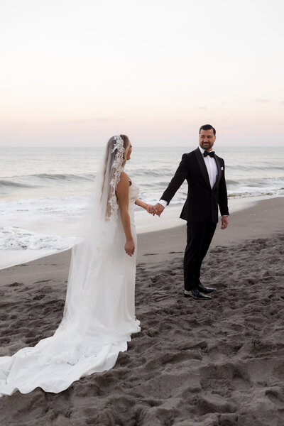 bride-and-groom-at-the-beach-holding-hands