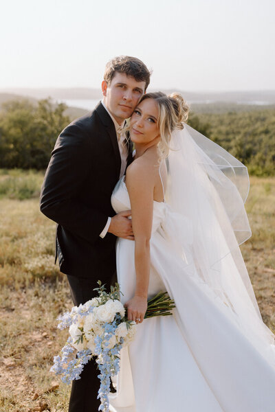 A wedding couple together with a blue boquet.