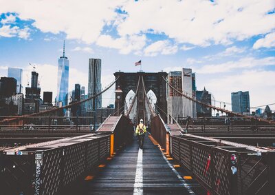  Construction worker on Brooklyn Bridge with New York City skyline in background, symbolizing Ambroselli Construction’s presence in NYC.