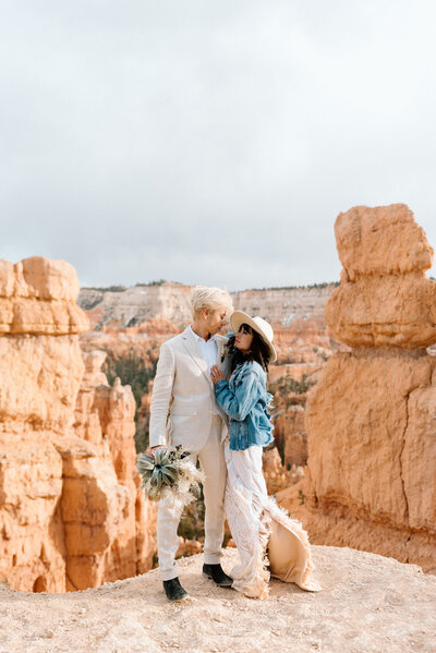 bride wearing  a boho dress dirty from hiking trails and a personalized jean jacket in Bryce Canyon National Park