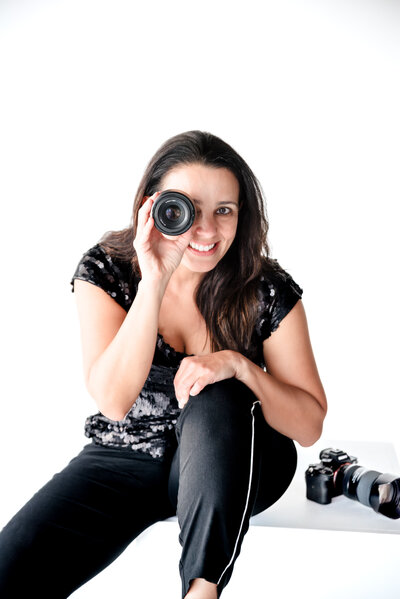 photo of a brand photographer  poses with a lens close to her eye