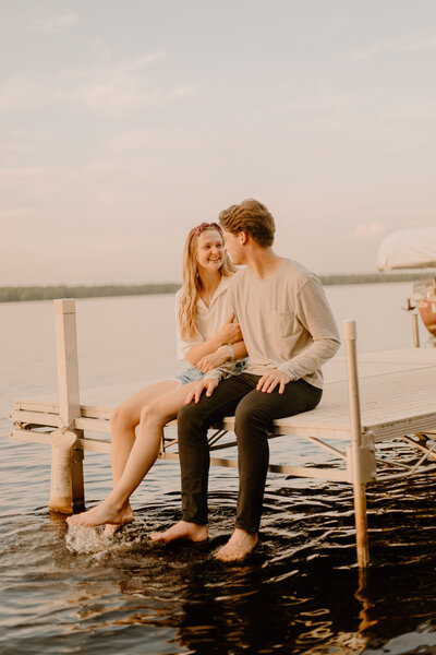 Man and woman sitting while hugging by a lake