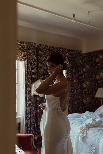 A Bride checking her reflection in the mirror at Hotel Boulderado before getting married in Colorado