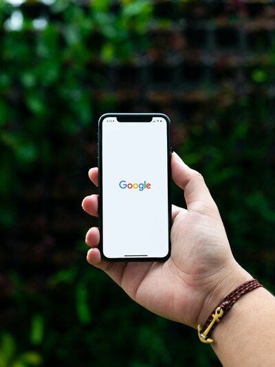 iphone in hand with google search