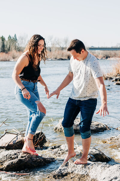 Engagement photo of Missoula couple laughing in the Clark Fork River