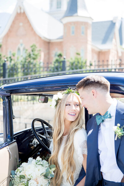 A bride and groom looking at each other next to a vintage blue car with las vegas wedding and portrait photographer, Jessica Bowles